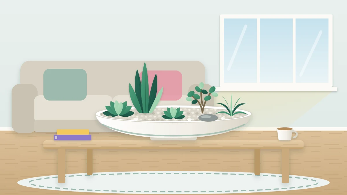 Wide shallow ceramic bowl on a coffee table planted with five small plants of different shapes, pale pebbles and one smooth stone